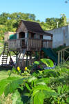 Playset with swings, climbing wall, clubhouse, and sand box for the children
